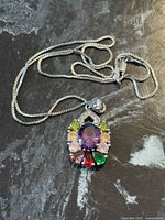 Necklace laid flat showing box chain, pendant front, lobster clasp