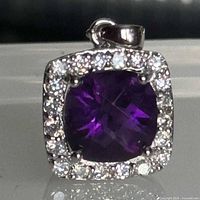 Front view of sterling silver halo pendant showing purple stone and CZ border