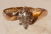 Front view of yellow gold ring showing marquise cluster setting
