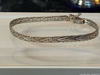 Full view of woven sterling bracelet laid flat showing overall design and thickness