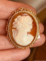 Front view of cameo brooch showing carved profile and filigree frame