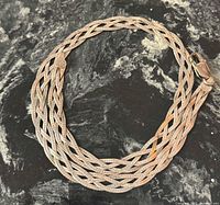 Full view of braided sterling silver necklace in coiled position