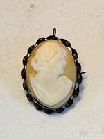 Front view of oval shell cameo brooch pendant