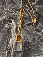 Full view of necklace showing chain, oval links, clasp, and crystal padlock pendant