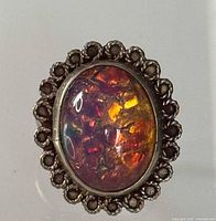 Front view of sterling silver ring with multicolour opal cabochon and scalloped border