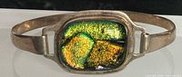 Front view showing sterling cuff and green dichroic glass cabochon