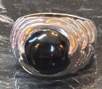 Front view of sterling ring showing black onyx cabochon and sculpted silver ridges