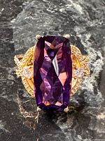 Front view showing amethyst-tone stone, clear accents and gold filigree shoulders