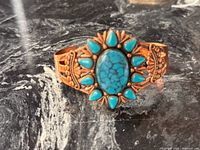 Front view of copper cuff showing turquoise arrangement and stamped detailing