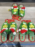 All three pairs of new Grinch slippers shown together
