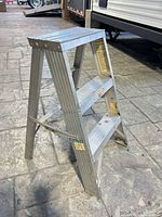 Full side view of aluminum step ladder folded open