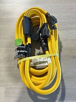 Coiled yellow Briggs & Stratton generator adapter cord with label visible