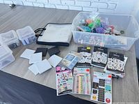 Overview of sticker books, beads, washi tape, canvases, binder and storage tote