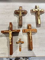 Five crucifixes laid out on surface