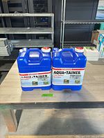Pair of Aqua-Tainer jugs on table showing fronts