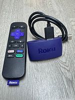 Roku 3960X streaming player, remote, HDMI cable on wood surface