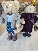 Both dressed teddy bears standing on table