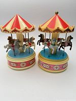 Both carousel music boxes side by side showing overall design and condition