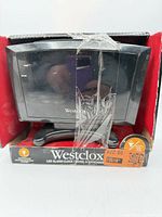 Clock in open box sealed with tape