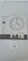 Front of boxed Better Living wall clock showing product image and features