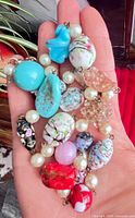 Close-up of assorted Murano glass beads and faux pearls in hand