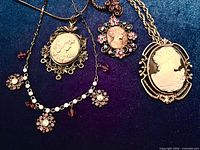 Group shot of four cameo necklaces on blue background