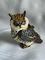 Front view of enamel owl trinket holder showing amber crystals on head and blue crystals on wing
