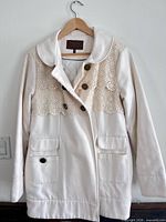 Front view of cream Gentle Fawn coat on hanger