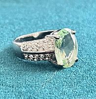 Side view of sterling silver ring showing green amethyst and pavé shoulders
