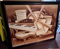 Front view of framed sepia-toned painting showing musical instruments composition