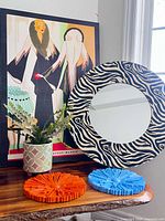 All items: canvas art print, zebra mirror, faux potted plant, orange and blue wall plaques