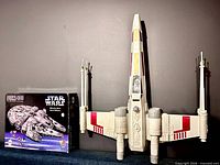 X-Wing Fighter beside boxed Millennium Falcon puzzle