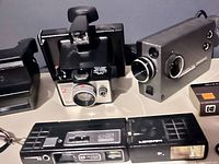 All five cameras grouped together: Polaroid Spirit, Kodak Instamatic 2, Kodak Instamatic M4 movie camera, Hanimex 110 camera, Winner pocket camera