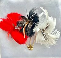 Front view of three feather hat pins showing colors and feather details