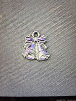 Silver tone bells charm with bow and slight purple enamel