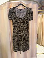 Front view of tan and black leopard print bodycon dress on hanger