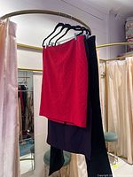 Red, black and dark purple skirts hanging on rack