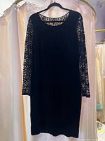 Black velvet dress with lace sleeves displayed on hanger