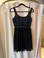 Front view black chiffon fit-and-flare dress on hanger