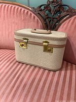 Beige McBrine train case closed showing brass locks and handle