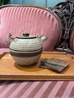 Teapot and coasters on tray, front view