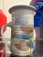 Front view of tall ceramic jug showing abstract brush decoration and handle