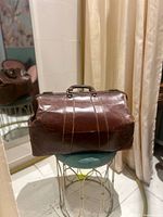 Front view of brown leather doctor’s bag showing handle, frame and wear