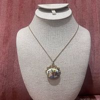 Porcelain floral pendant necklace on display bust