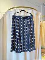 Full view of navy pleated skirt on hanger