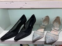 Both pairs of shoes side by side on shelf