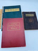 Front covers of three atlases: green International Atlas, red Hammond's Perpetual Atlas, brown Atlas of the World