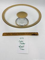 Full view of glass pedestal cake platter with ruler for scale