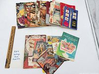 All 30 vintage cook booklets spread out on table
