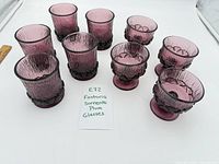 Full set of nine Fostoria Sorrento plum glasses arranged on table